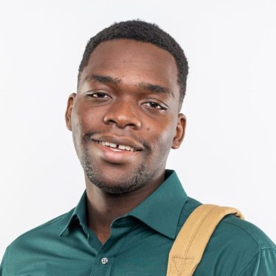 smiling young afro-american student with backpack holding books and looking at camera isolated on white background with copy space